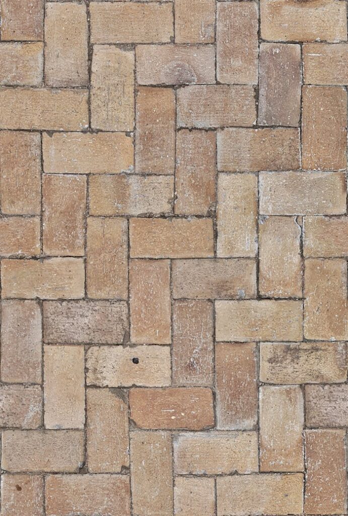 High-resolution image of a herringbone pattern brick pavement showcasing earthy tones.